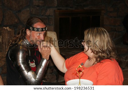 MUSKOGEE, OK - MAY 24: A Renaissance knight greets women at the Queen\'s tea party during the Oklahoma 19th annual Renaissance Festival on May 24, 2014 at the Castle of Muskogee in Muskogee, OK.