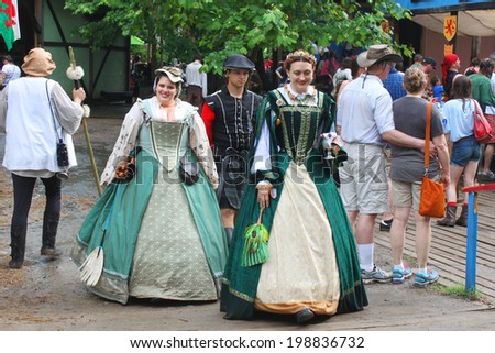 MUSKOGEE, OK - MAY 24: Women dressed in historical costume walk around the village at the Oklahoma 19th annual Renaissance Festival on May 24, 2014 at the Castle of Muskogee in Muskogee, OK.
