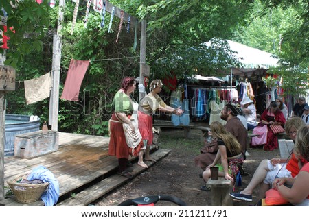 MUSKOGEE, OK - MAY 24: Women wash laundry old way at the Oklahoma 19th annual Renaissance Festival on May 24, 2014 at the Castle of Muskogee in Muskogee, OK.