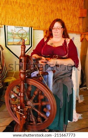 MUSKOGEE, OK - MAY 24:  A woman works at a vintage spinning wheel making yarn at the Oklahoma 19th annual Renaissance Festival on May 24, 2014 at the Castle of Muskogee in Muskogee, OK