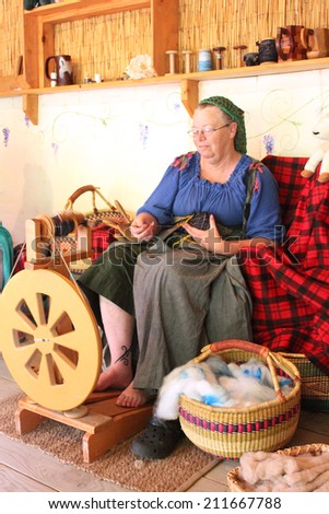 MUSKOGEE, OK - MAY 24:  A woman works at a vintage spinning wheel making yarn at the Oklahoma 19th annual Renaissance Festival on May 24, 2014 at the Castle of Muskogee in Muskogee, OK
