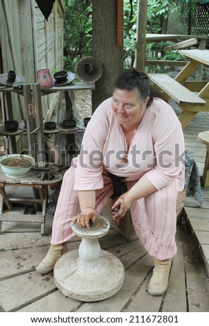MUSKOGEE, OK - MAY 24: A potter shows of her craft on the spinning wheel at the Oklahoma 19th annual Renaissance Festival on May 24, 2014 at the Castle of Muskogee in Muskogee, OK