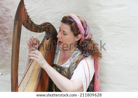 MUSKOGEE, OK - MAY 24: Woman dressed in vintage clothes plays harp at the Oklahoma 19th annual Renaissance Festival on May 24, 2014 at the Castle of Muskogee in Muskogee, OK
