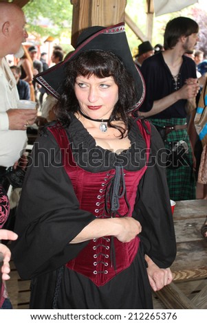 MUSKOGEE, OK - MAY 24: Woman dressed in historical costume walks around the village at the Oklahoma 19th annual Renaissance Festival on May 24, 2014 at the Castle of Muskogee in Muskogee, OK.