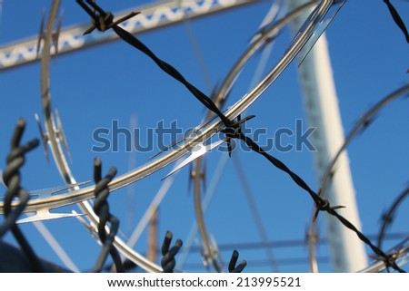 Metal fence with razor wire on top