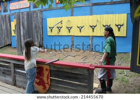 MUSKOGEE, OK - MAY 24: Men try their luck at a weapon range game during the Oklahoma 19th annual Renaissance Festival on May 24, 2014 at the Castle of Muskogee in Muskogee, OK.