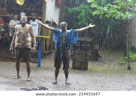 MUSKOGEE, OK - MAY 24: Grown men enjoy water and mud after rain at the Oklahoma 19th annual Renaissance Festival on May 24, 2014 at the Castle of Muskogee in Muskogee, OK.