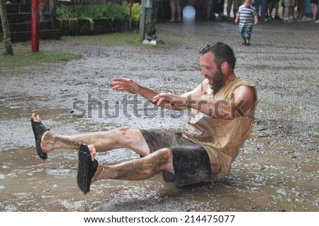 MUSKOGEE, OK - MAY 24: Grown men play in water and mud after rain at the Oklahoma 19th annual Renaissance Festival on May 24, 2014 at the Castle of Muskogee in Muskogee, OK.