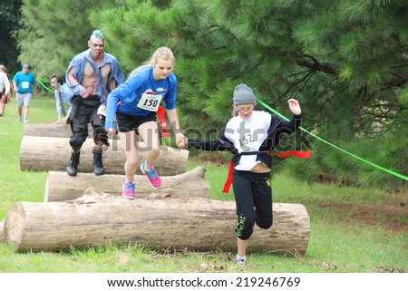 MUSKOGEE, OK - Sept. 13: A young athlete tries to avoid bloody zombies during the Castle Zombie Run at the Castle of Muskogee in Muskogee, OK on September 13, 2014.