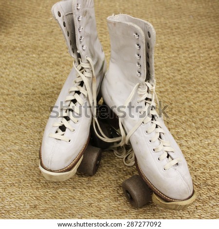 Old worn roller skates with big shoe-laces