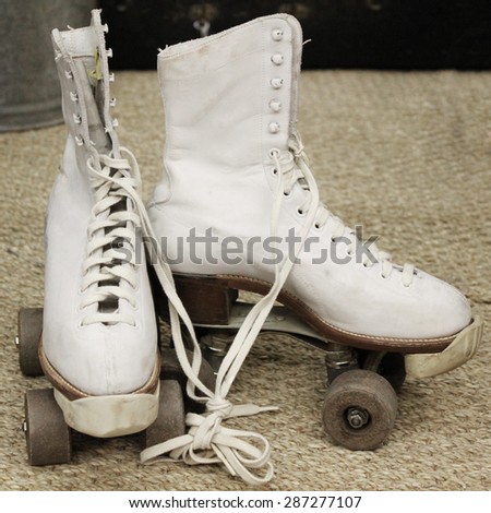 Old worn roller skates with big shoe-laces