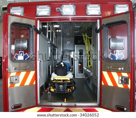 Paramedic's truck with open back doors, where stretcher and medical equipment is visible. All trademarks, names and identifications removed.