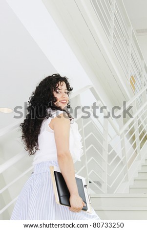 Young casually dressed business woman going upstairs