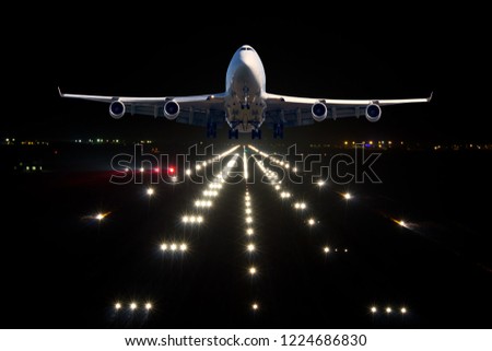 A passenger plane takes off from the night airport runway. Airplane front view.