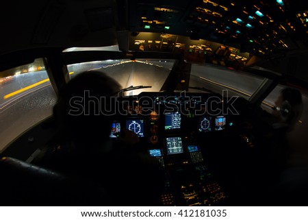 Night view from the airplane cockpit. The aircraft is moves for take off from the airport runway.
