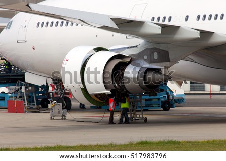 Engine of passenger jet aircraft with open hoods closeup. Engineers and technicians repair the engine of airplane.
