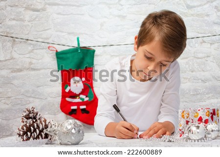 Boy writes a letter to Santa Claus.