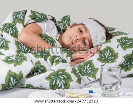 Sick boy lying in bed with high fever