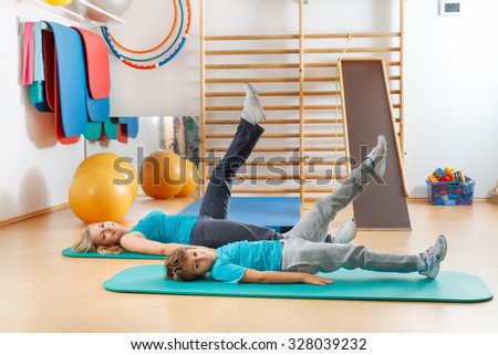 Happy, sports family, mother and son perform gymnastic exercises.