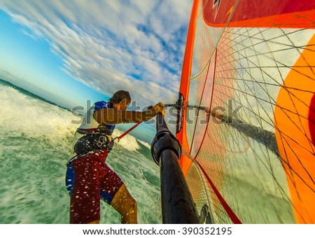 Selfie photo of windsurfing riding on colored sail