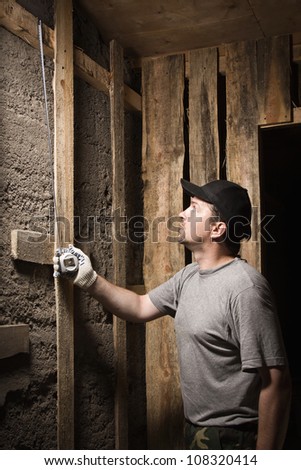 Builder measures the wall height of the tape