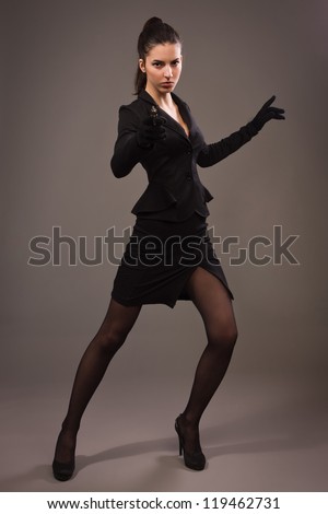 Spy girl in a black suit shoots a gun
