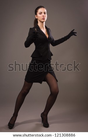 Spy girl in a black suit shoots a gun
