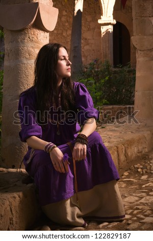 Brunette girl in a medieval suit in a Agia Napa Medieval Monastery background - stock photo