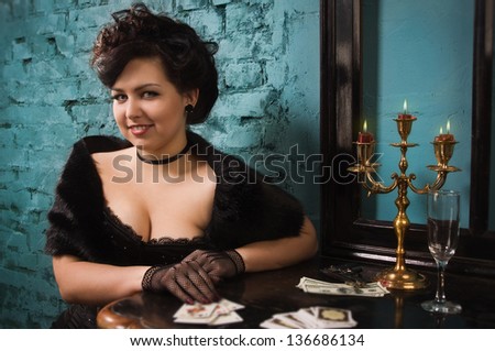 The pretty woman with cards in the vintage interior