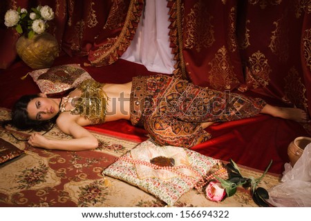 Crime scene imitation: lifeless woman in a traditional oriental costume lying on a floor