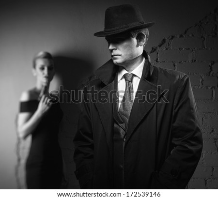 Film Noir. Detective Man In A Raincoat And Hat And A Dangerous Woman With A Gun In His Hand
