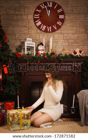 Young woman in a wool sweater with Christmas gifts