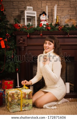 Young woman in a wool sweater with Christmas gifts