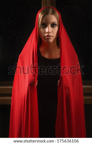 girl in a red cape against the starry sky