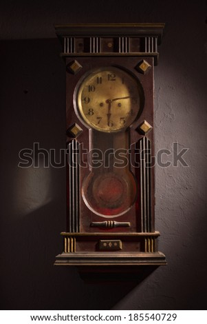 Old wooden grandfather clock hanging on a wall