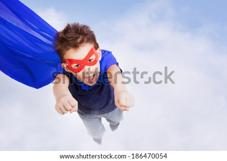 Superhero kid against blue sky background