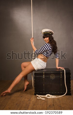 Adorable woman sailor in pinup style wearing sea admirals hat and sexy top