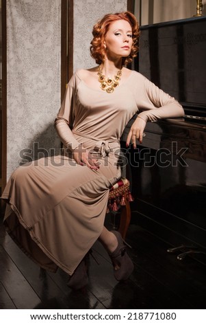 Pretty woman in evening dress and piano