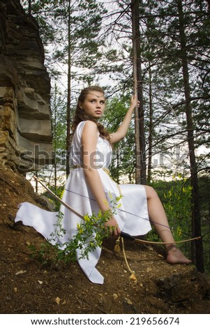 young girl with a bow in the forest