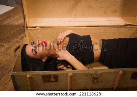 Crime scene in a vintage style. Pretty victim lying in the suit-case
