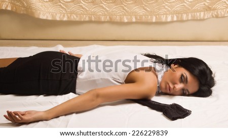 Crime scene simulation. Strangled victim lying on the floor in a luxury bedroom