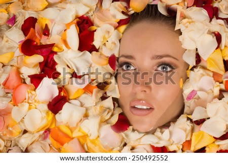 Beautiful sexy woman in bath with flowers petals. Spa body care.