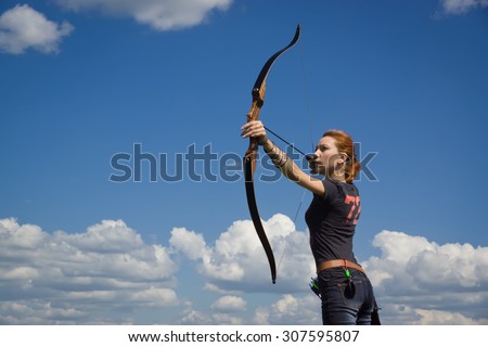 Archery woman bends bow archer target narrow in the summer field