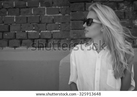 Fashion outdoor photo of beautiful woman wearing elegant clothes and posing in city street