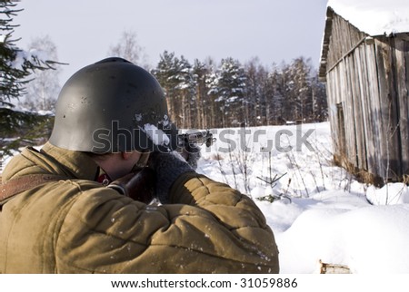 Soviet-Finnish war: Red Army soldier aims from a rifle. Kind from a back