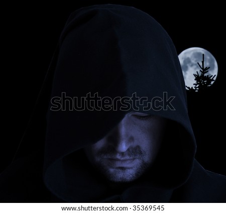 Man in an ancient hood on a full moon background