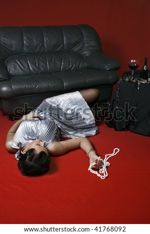 Poisoned young woman on the floor. Studio shot in a retro style