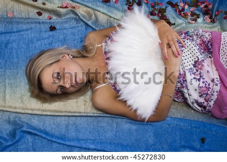 Romantic portrait of the young beautiful girl with a fan