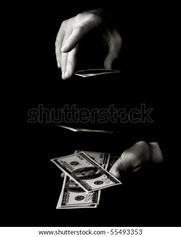 Hand with packs of dollars over black
