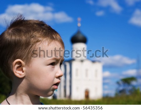 Little boy on a  orthodox church background. Church of the Intercession on the Nerl (Vladimir region of Russia)
